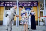 Первый заместитель мэра Сергей Фролов вручает символический ключ директору школы Ирине Косиновой