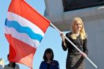 Татьяна Руденок, региональный замминистра по делам молодежи, физической культуры и спорта, вручает флаги Омской области